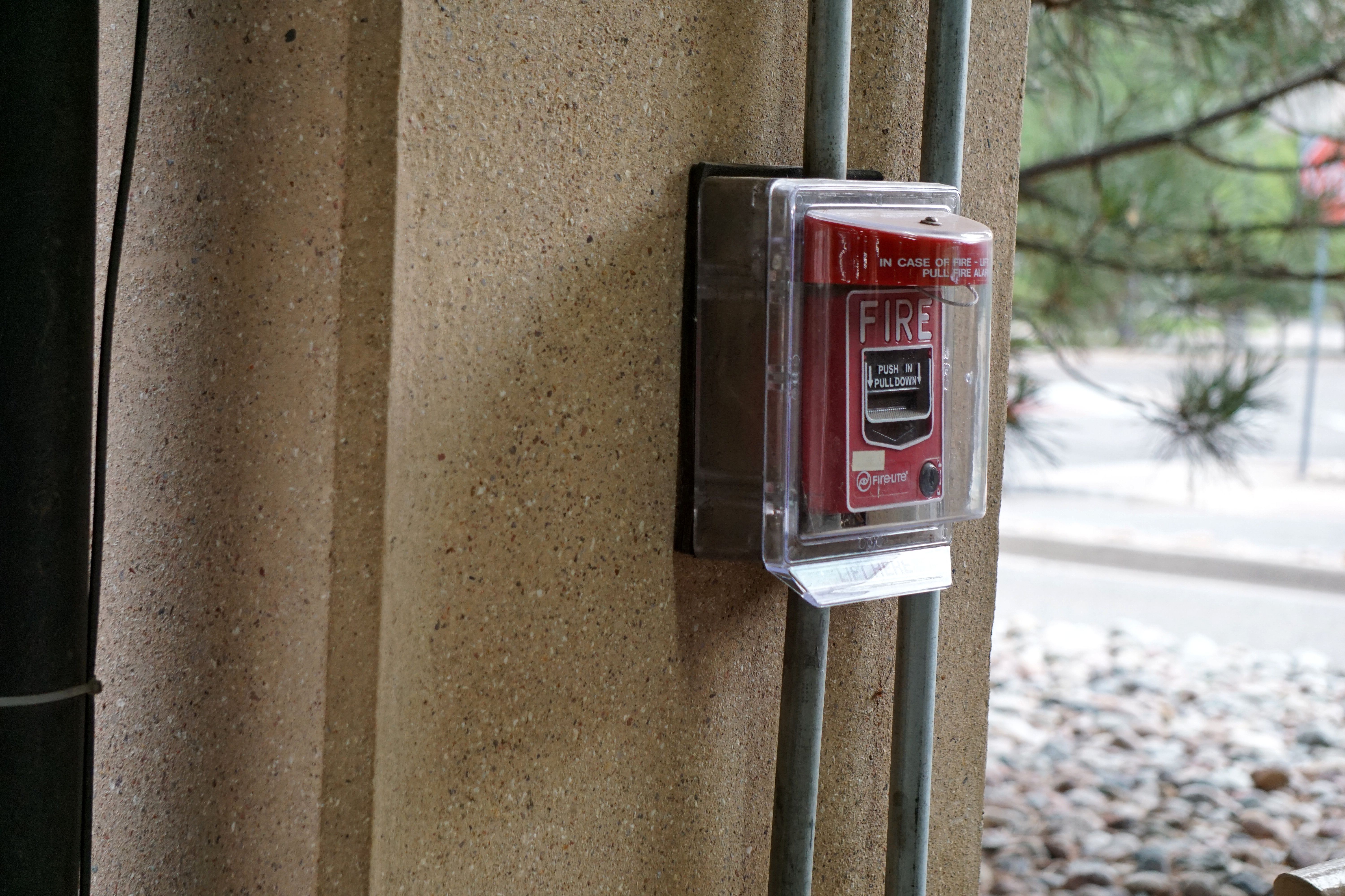 Red fire alarm call point mounted on a wall