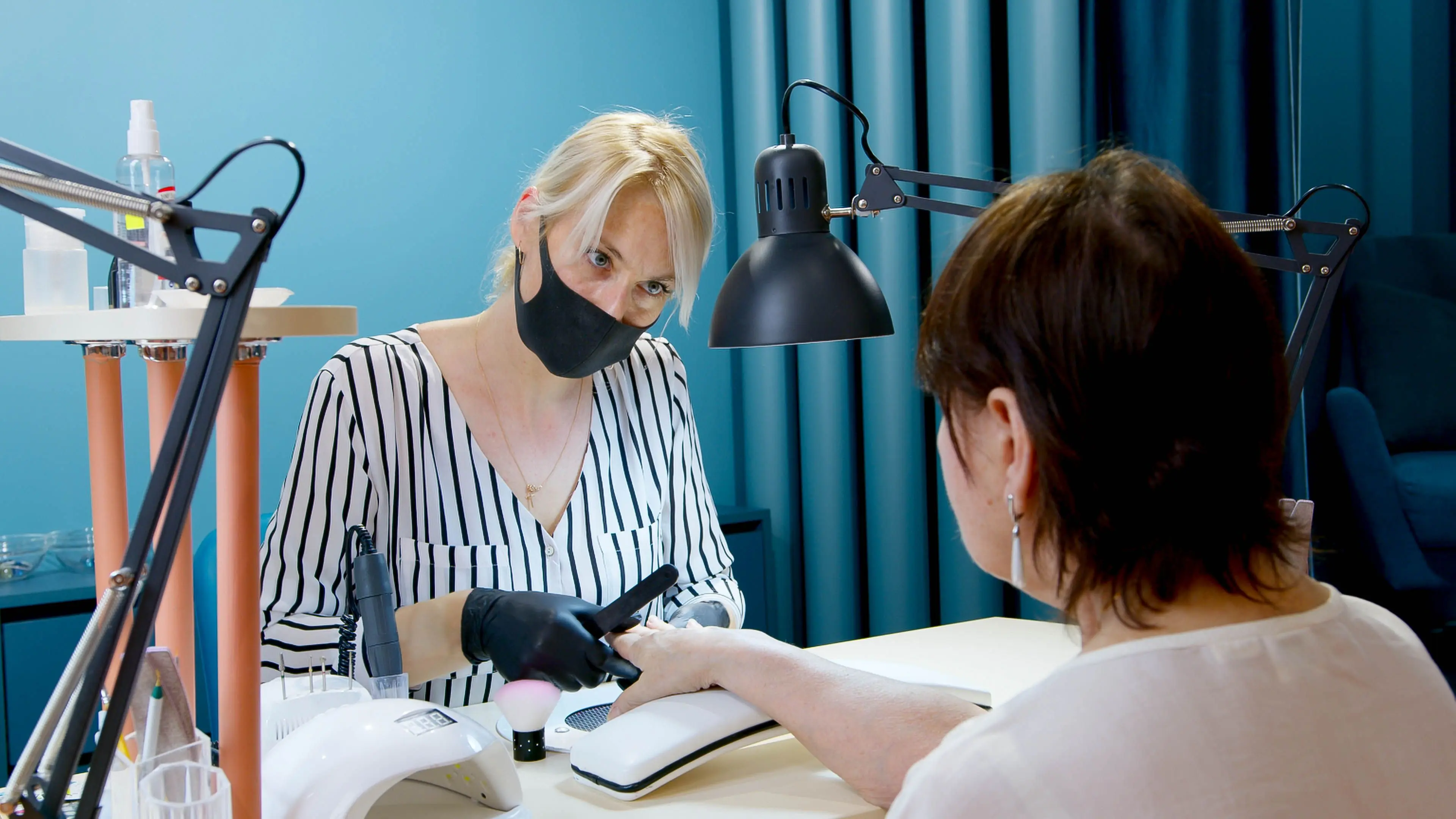 Technician treating a client in a nail salon