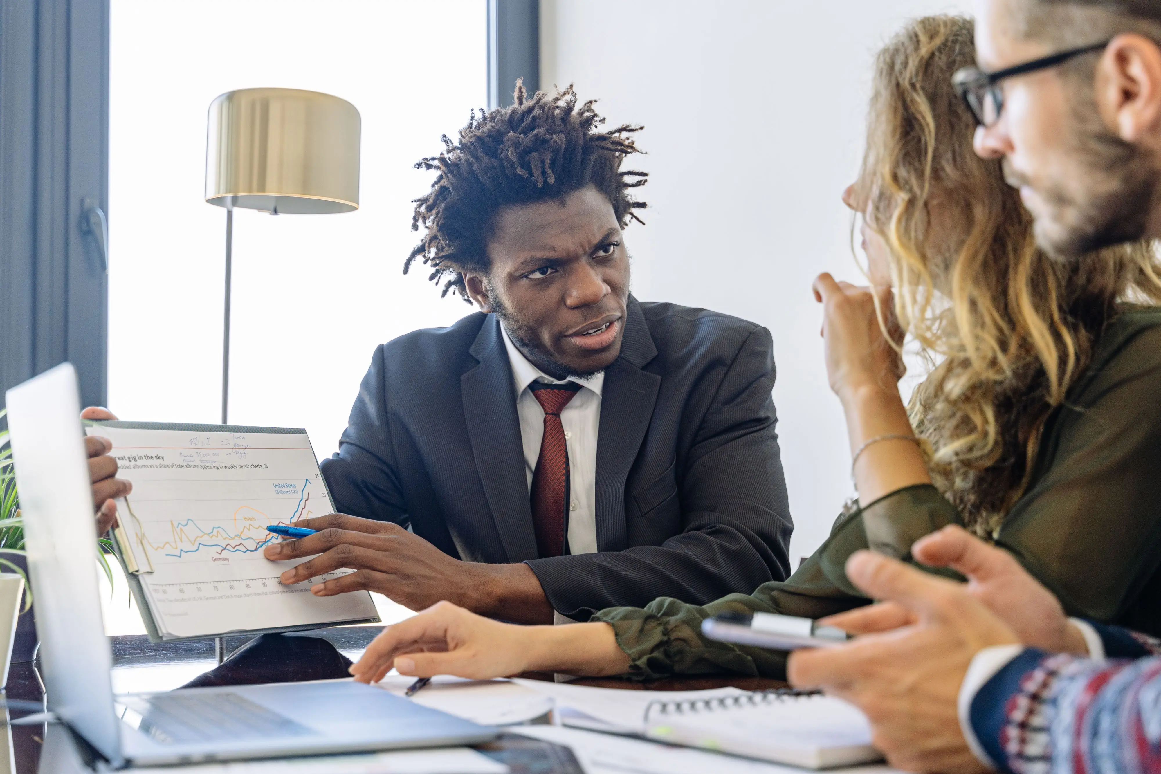 Colleagues meeting around a laptop in a modern office